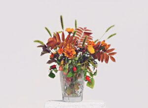 Autumn flowers and leaves in a cristal vase